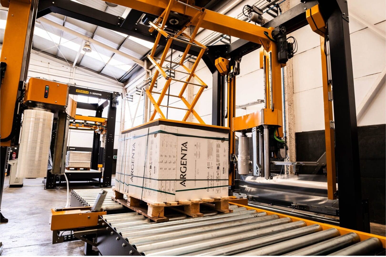 Arm stretch wrapping machine for reduced film consumption