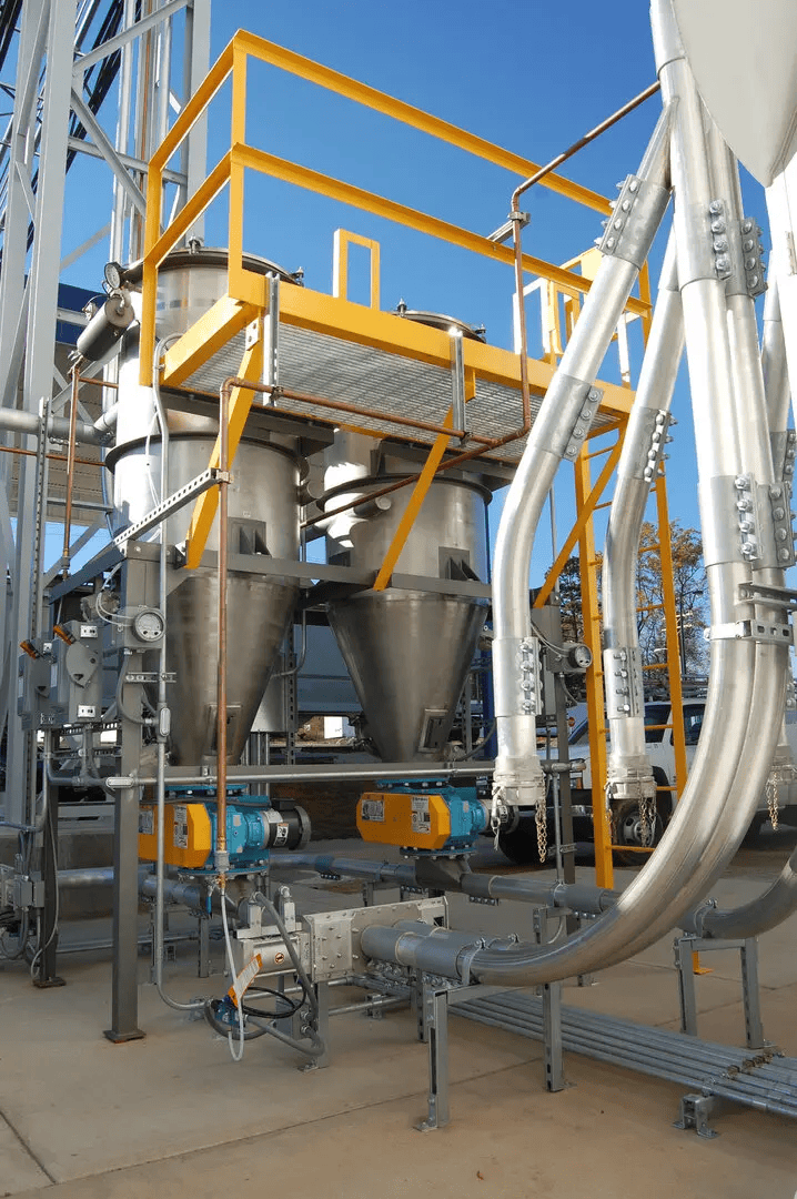 Dual stainless steel filter receivers in a plastics conveying system