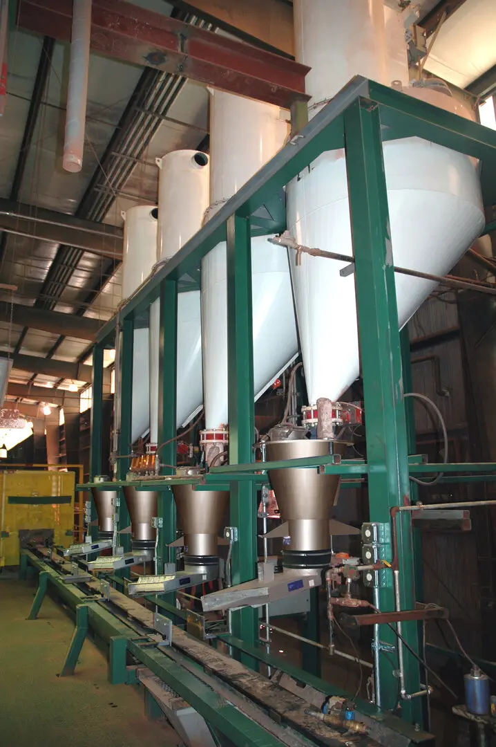 Storage hoppers and vibratory feeders integrated over a production line
